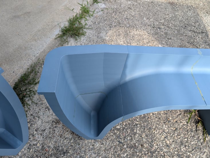 Top-down detail of a motorcycle trailer fender end section showing a clean section joint