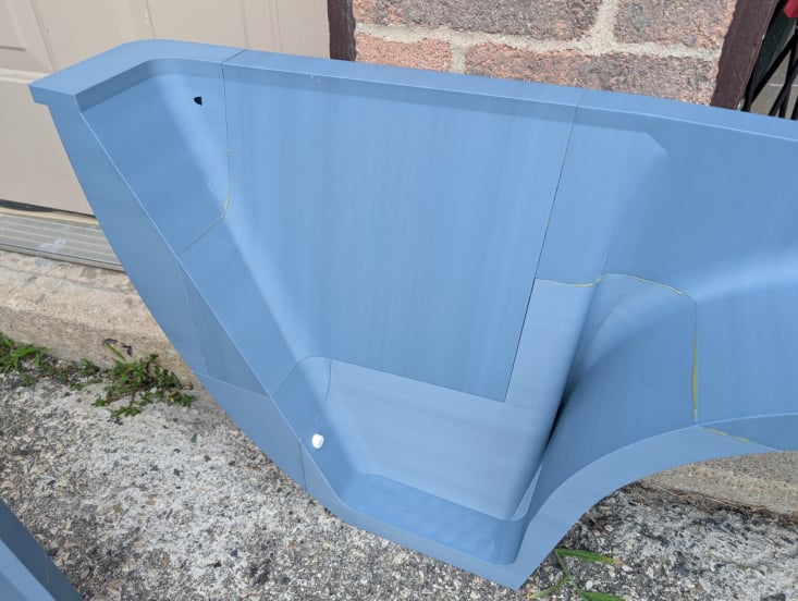 Close detail of the motorcycle trailer fender side wall showing the printed surface and section seam