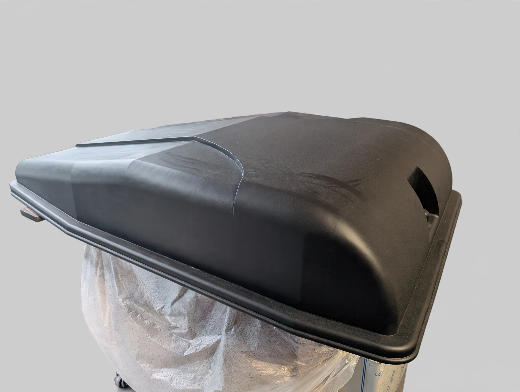 Primer-coated motorcycle trailer lid with a smooth matte black finish ready for delivery